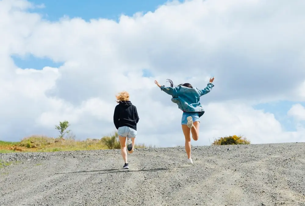 young-female-friends-jumping-on-road